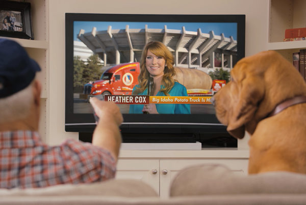 Idaho Potato Farmer in blue hat with dog sitting on couch watching TV of EvansHardy+Young Commercial