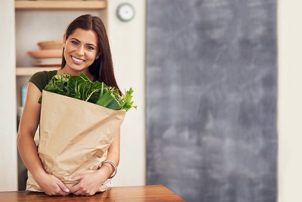 Woman holding brown bag of produce