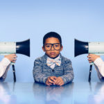 Two professional kids yelling with bullhorns at middle kid on light blue background