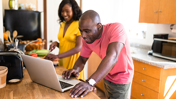 couple in kitchen with Mac researching recipes