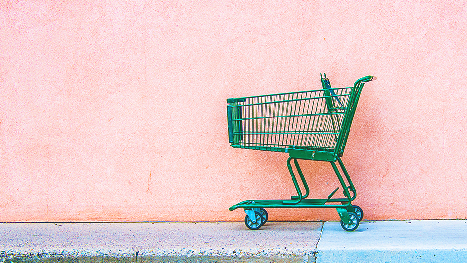 empty green grocery shopping cart on pink background