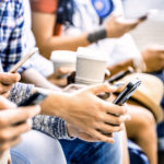 Millennials sitting with coffee looking at phone for Social Media Marketing