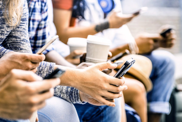 Millennials sitting with coffee looking at phone for Social Media Marketing