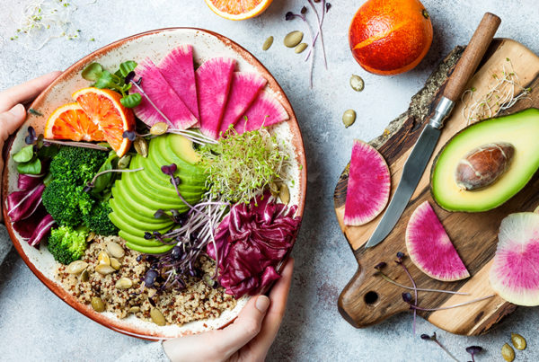 hands holding plate of plant based foods